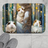 Cosmic Cavy TripTych Guinea Pig Bath Mat -- a rectangular bath mat with rounded corners featuring a whimsical Art Nouveau-style illustration of a woman embracing guinea pigs, shown on a light gray tiled floor with gray knit slippers at the bottom left. – image 3