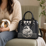 Echoes in Ink guinea pig shoulder handbag beside an owner holding a guinea pig in a cozy reading chair – image 7