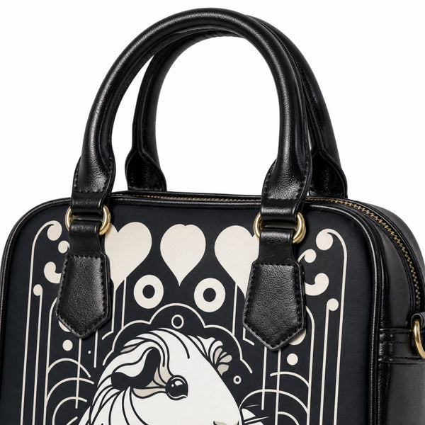 Black shoulder handbag handles, gold-tone hardware, zipper, stitching, and printed material detail